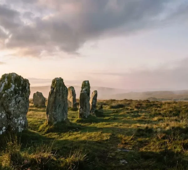 Atmospheric view of an ancient stone circle in misty British moorland at golden hour, capturing the essence of undiscovered heritage