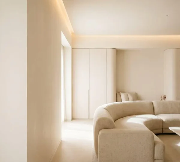 A serene minimalist family living room with clean lines, neutral tones, and hidden storage seamlessly integrated into wall design